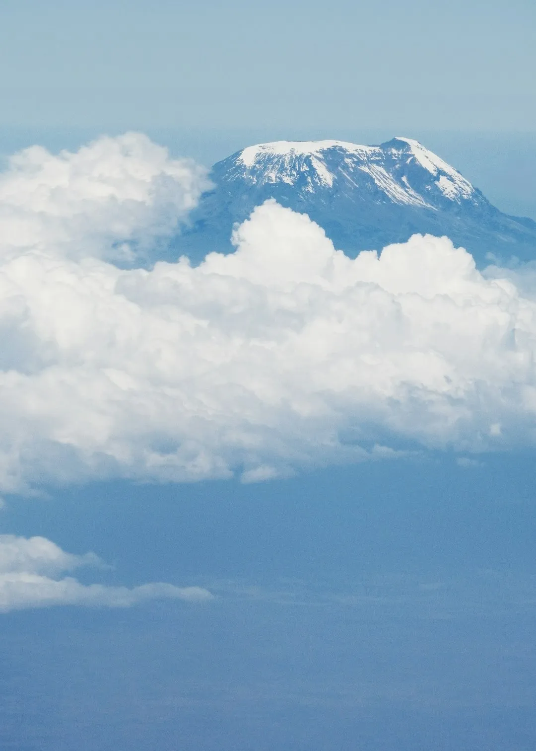 The snow-capped summit of Kilimanjaro rising above the clouds