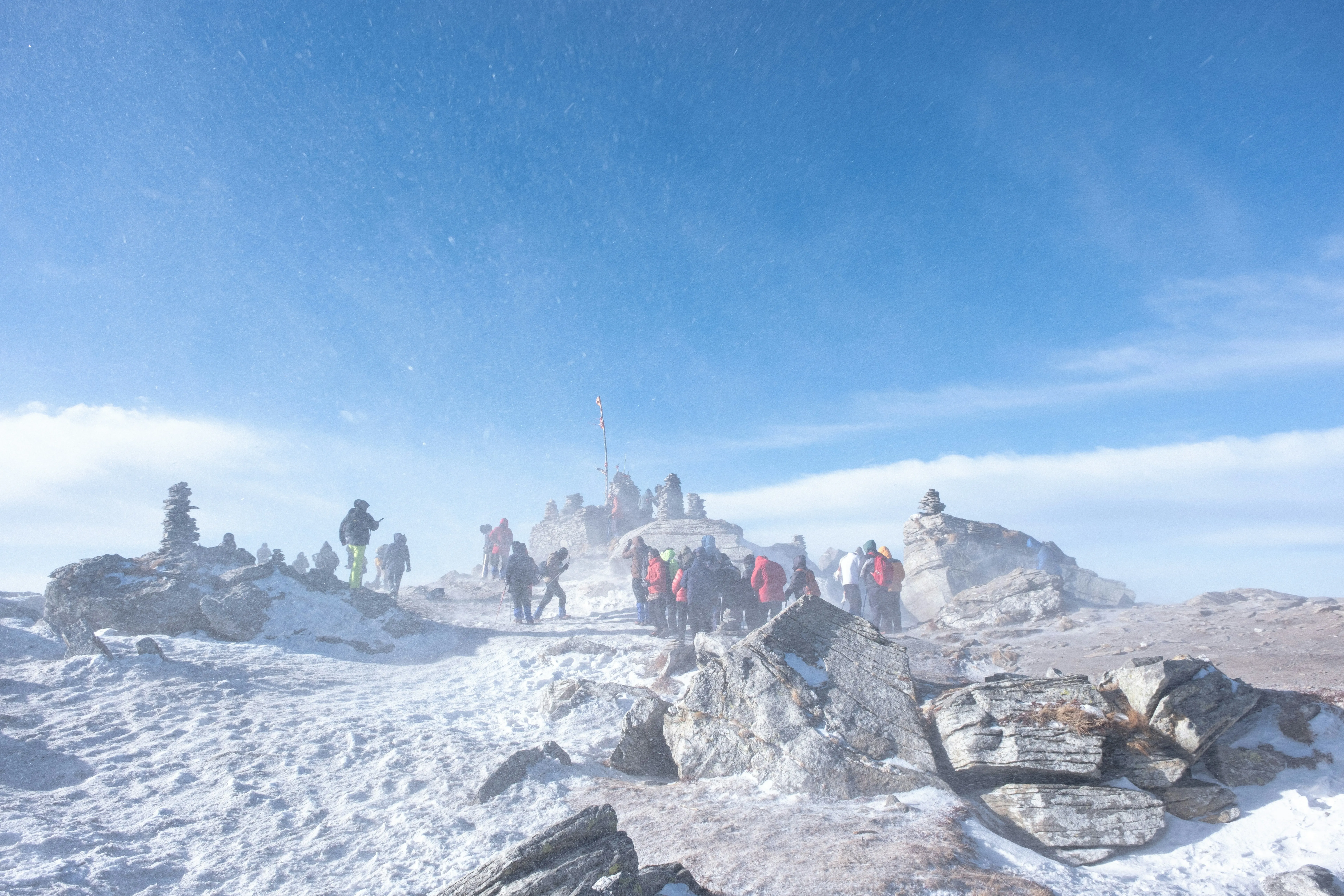 Climbers gathered at a wind-blown, snowy summit